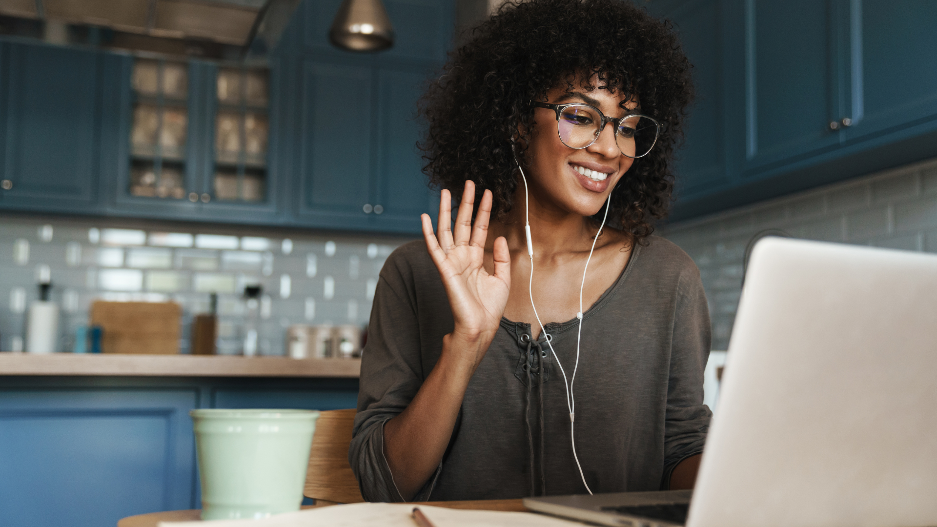 Woman waving during an online psychosexual therapy session at home